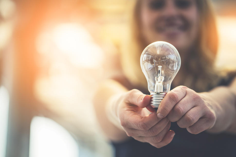 Woman holding a light bulb to represent new ideas and innovation