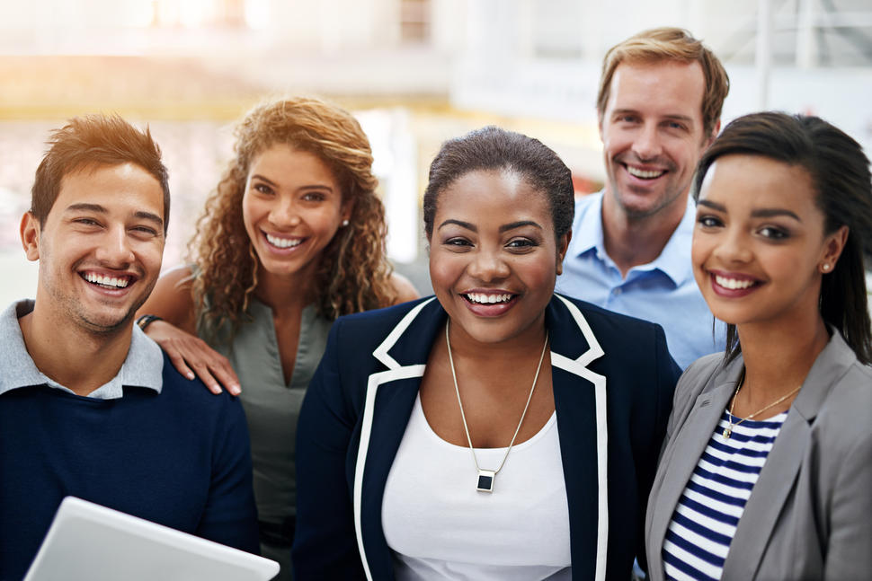 Young professional standing in a group smiling