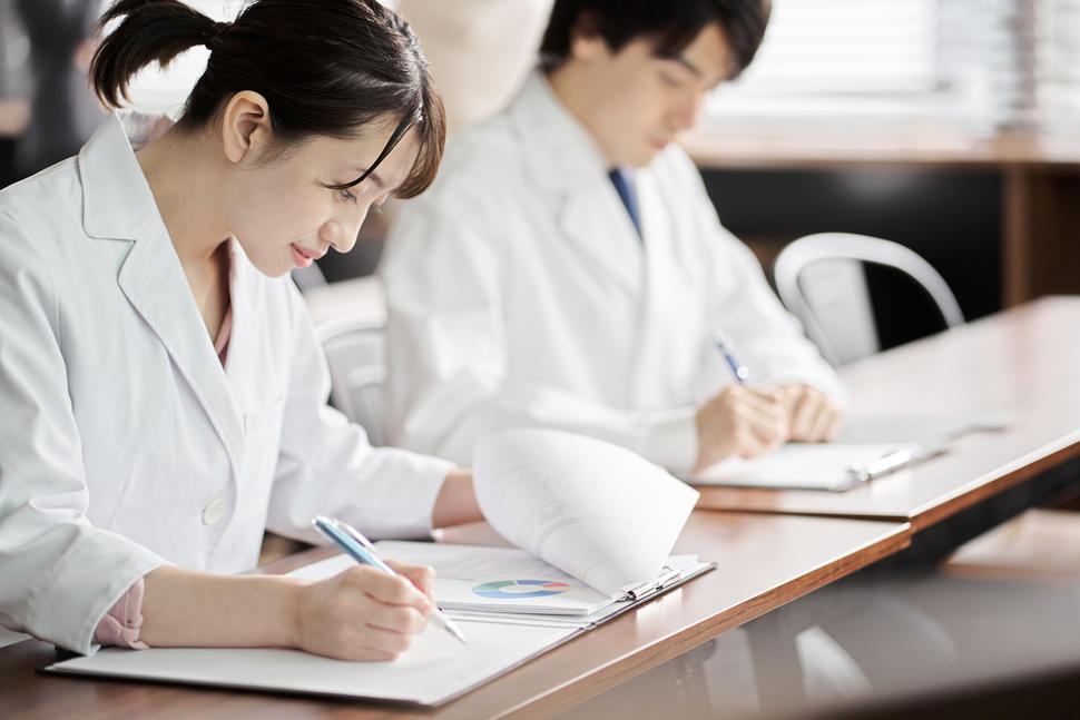 Researchers take notes to review publications