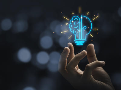 Hand holds lightbulb to represent new ideas