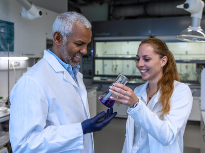 Researchers examine graduated cylinder for research materials